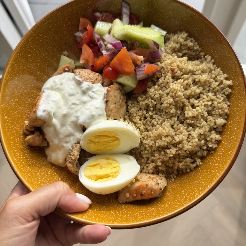 Quinoa met kip, gekookt ei, yoghurtsaus en tomaten-komkommersalade