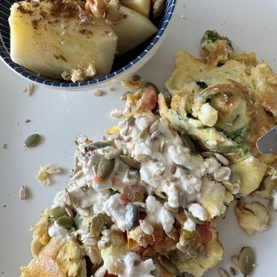 Omelet met groente, hüttenkäse en pitten, met een bakje appel en walnoot